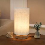 Minimalist bedside table lamp with round linen shade.